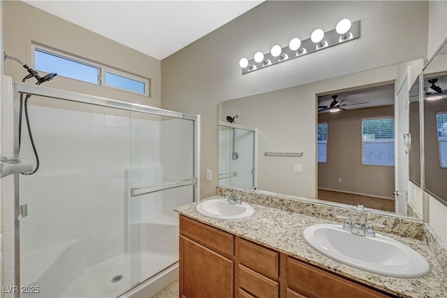 bathroom featuring an enclosed shower, vanity, and ceiling fan