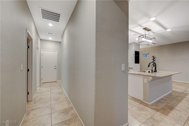 corridor with light tile patterned flooring and sink