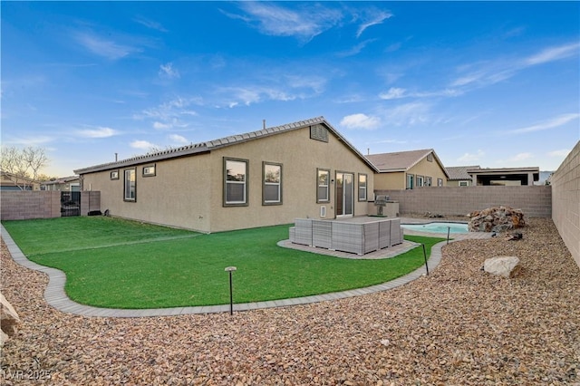 back of property with outdoor lounge area, a yard, and a pool