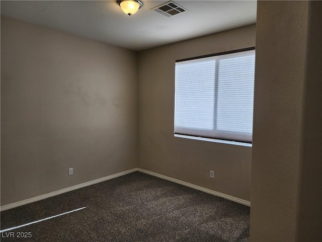 spare room with a wealth of natural light and dark colored carpet