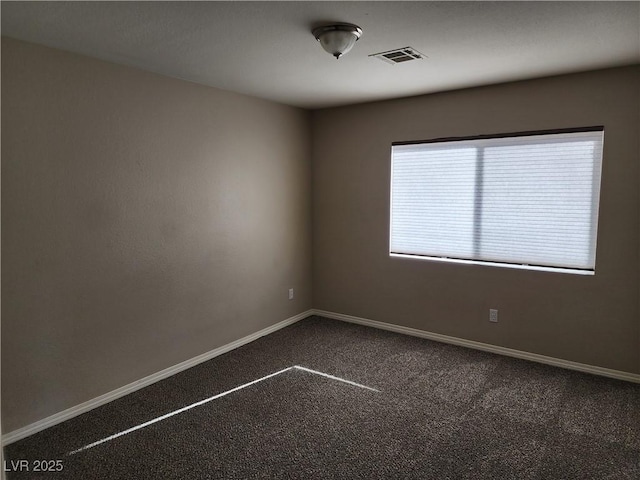 unfurnished room with dark carpet