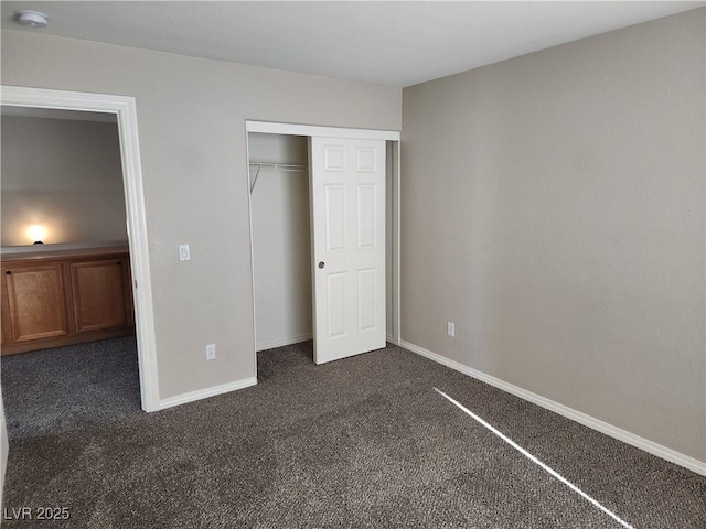 unfurnished bedroom with dark carpet and a closet