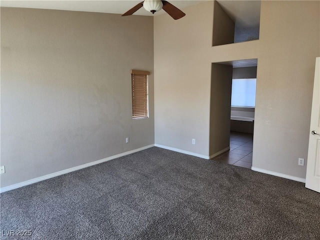 unfurnished room with a towering ceiling, light carpet, and ceiling fan