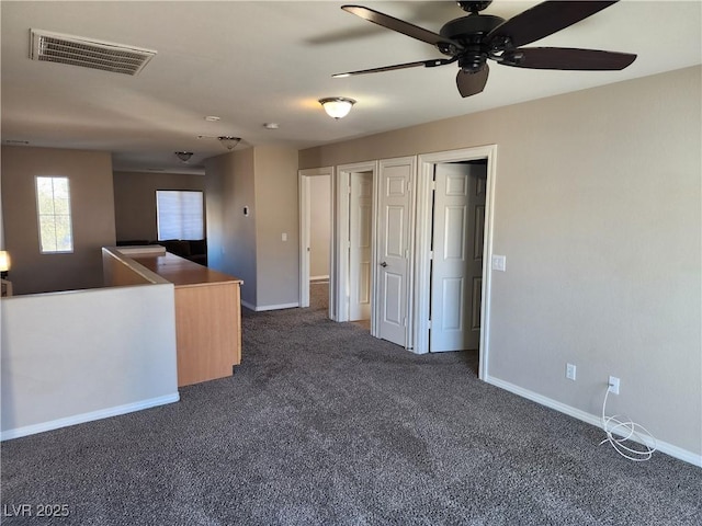 spare room with dark colored carpet and ceiling fan