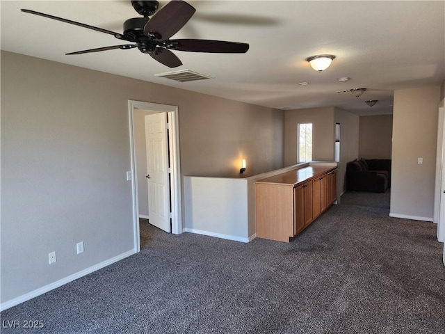 kitchen with dark colored carpet and ceiling fan