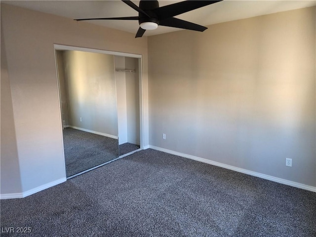 unfurnished bedroom with dark colored carpet, ceiling fan, and a closet