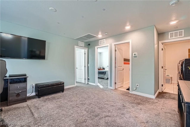 carpeted bedroom with ensuite bathroom and a walk in closet