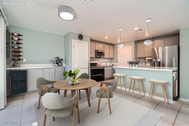 dining area featuring beverage cooler and light tile patterned flooring