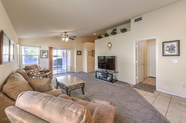 living room with ceiling fan, lofted ceiling, and light tile patterned flooring