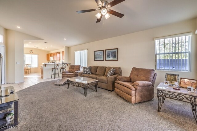 tiled living room featuring ceiling fan and lofted ceiling