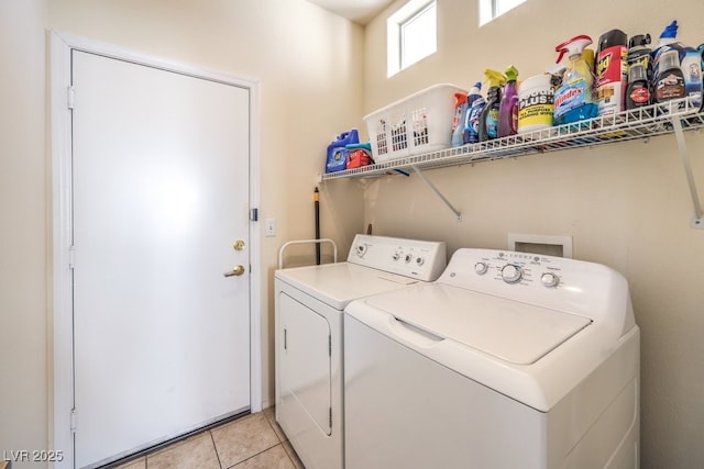 laundry area featuring light tile patterned floors and washer and clothes dryer