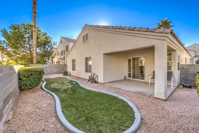 rear view of house featuring central air condition unit, a patio area, and a yard