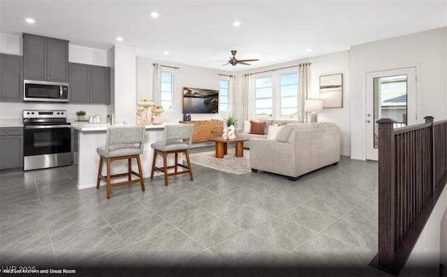 tiled living room featuring ceiling fan