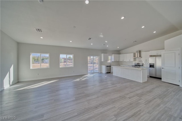 unfurnished living room with light hardwood / wood-style floors and vaulted ceiling