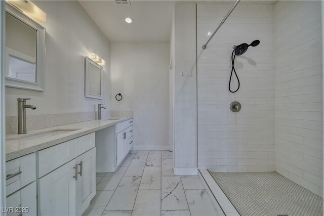 bathroom featuring vanity and tiled shower