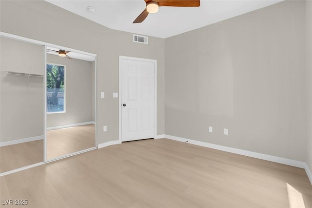 unfurnished bedroom with a closet, light hardwood / wood-style flooring, and ceiling fan