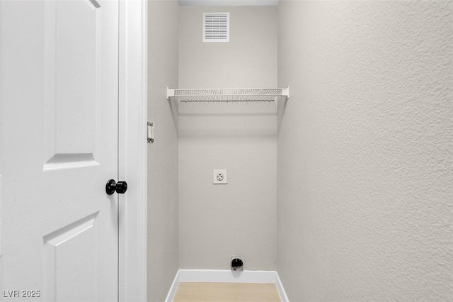 laundry room with electric dryer hookup and hardwood / wood-style floors