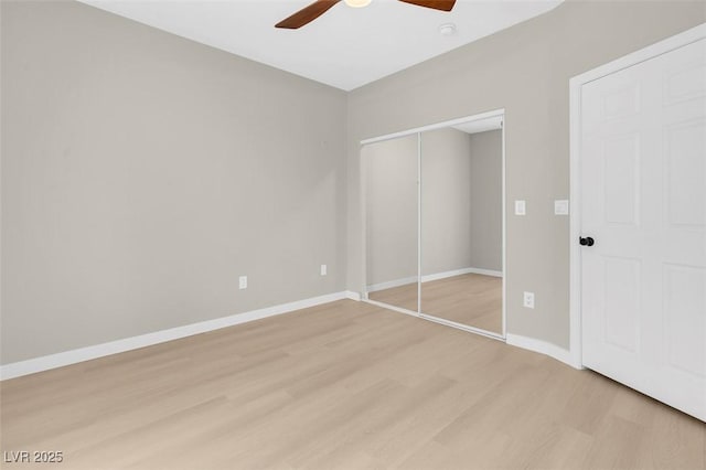 unfurnished bedroom with ceiling fan, light wood-type flooring, and a closet