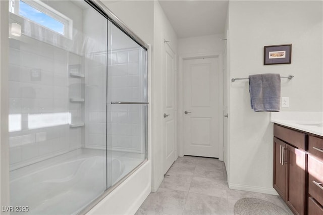 bathroom featuring enclosed tub / shower combo, tile patterned floors, and vanity