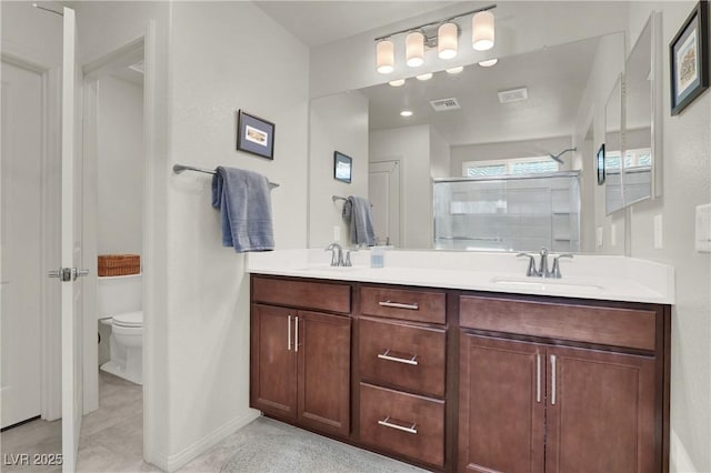 bathroom featuring tile patterned flooring, an enclosed shower, vanity, and toilet