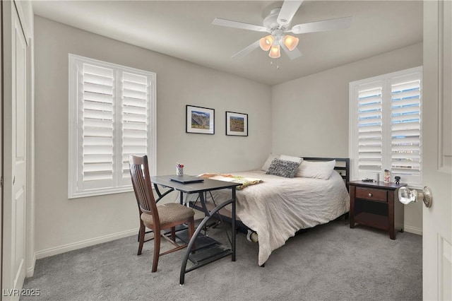 bedroom with light colored carpet, ceiling fan, a closet, and multiple windows