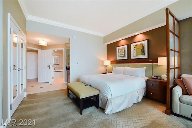 bedroom with french doors, crown molding, and ensuite bath