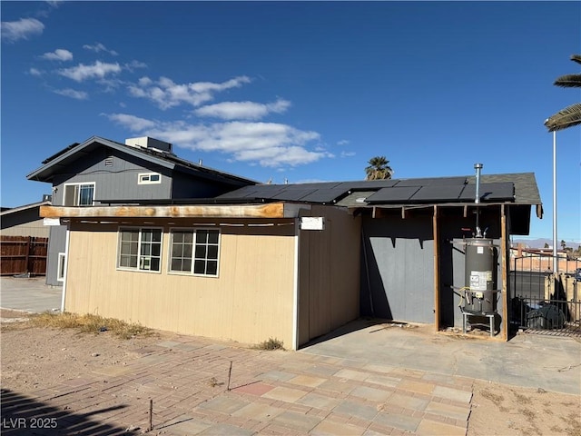 view of home's exterior featuring solar panels, a patio area, and gas water heater