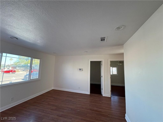 empty room featuring dark hardwood / wood-style flooring and a textured ceiling