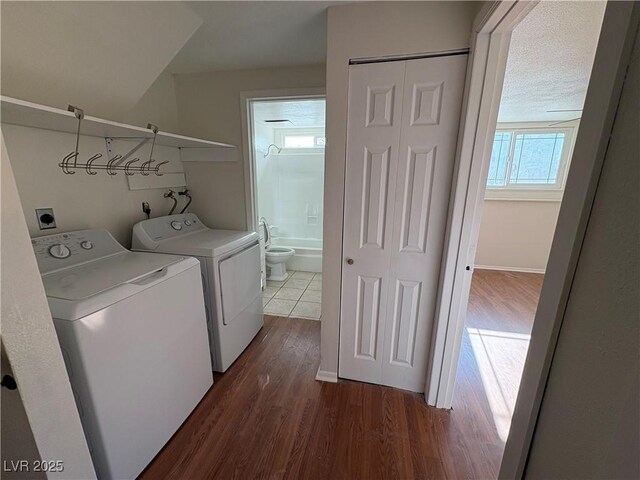 washroom with a textured ceiling, washer and clothes dryer, a wealth of natural light, and dark hardwood / wood-style floors