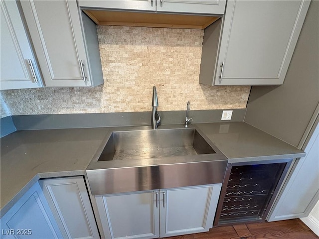 kitchen featuring decorative backsplash, sink, white cabinets, and dark hardwood / wood-style floors