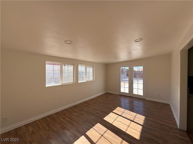 spare room featuring french doors and dark hardwood / wood-style flooring