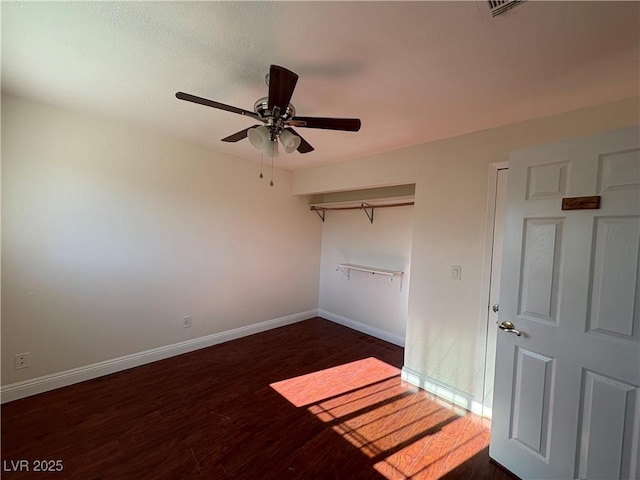 unfurnished room with ceiling fan and dark wood-type flooring