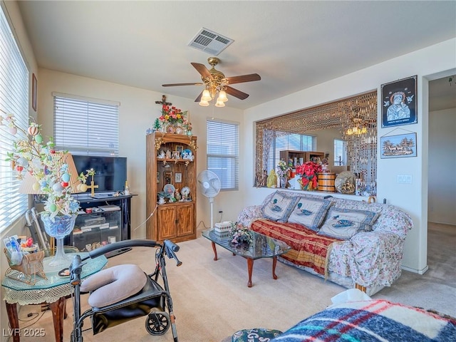 living room featuring carpet floors and ceiling fan with notable chandelier