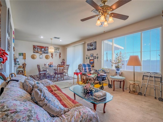 carpeted living room with ceiling fan