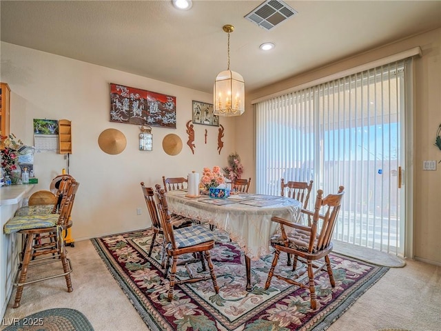 dining room featuring light carpet and an inviting chandelier