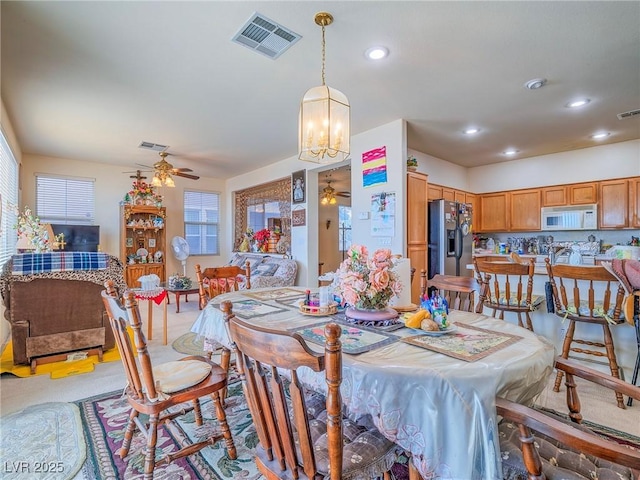 dining room featuring ceiling fan with notable chandelier