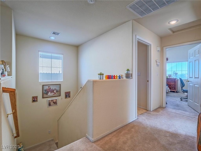 hallway featuring light colored carpet