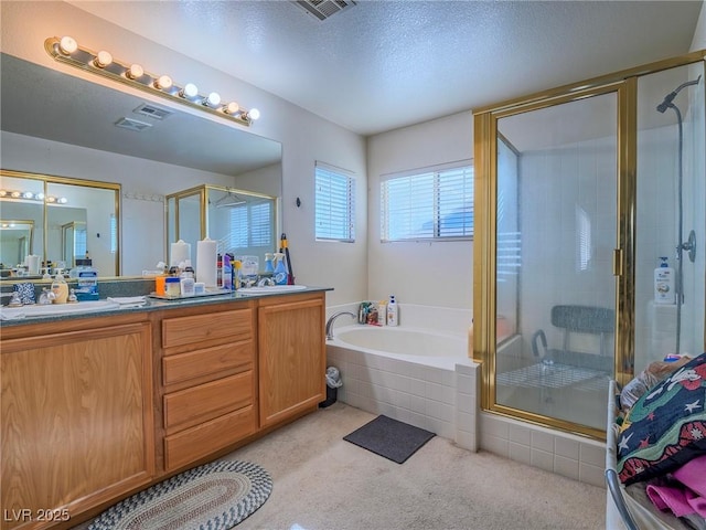 bathroom with separate shower and tub, vanity, and a textured ceiling