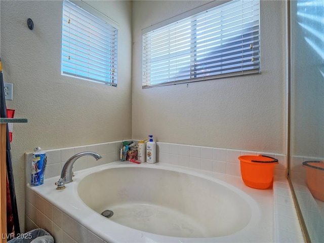 bathroom featuring vanity and tiled bath