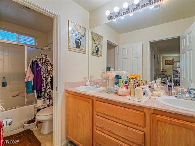 full bathroom with tile patterned floors, vanity, toilet, and shower / bath combination with glass door