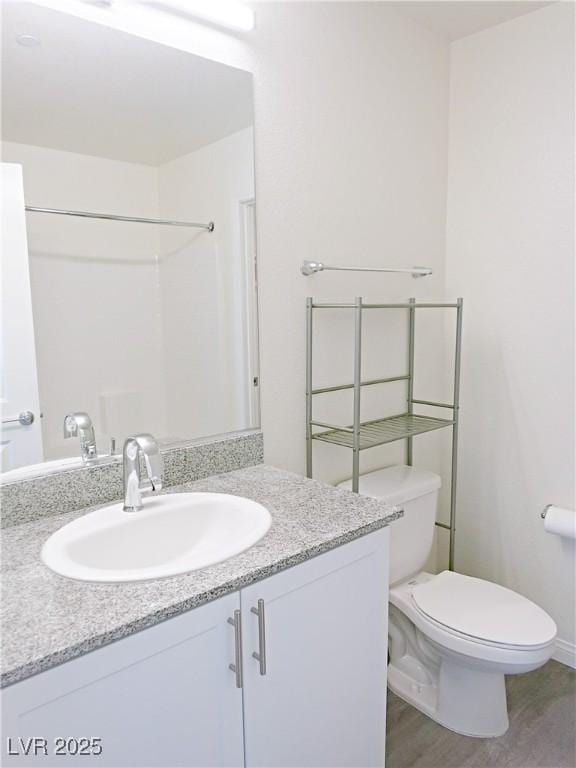 bathroom with vanity, hardwood / wood-style flooring, and toilet