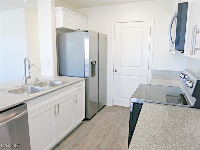 kitchen featuring white cabinets, light wood-type flooring, stainless steel appliances, and sink