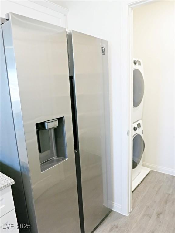 interior space featuring stacked washer and dryer and light hardwood / wood-style flooring