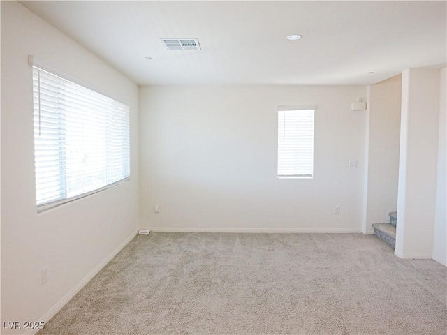 spare room with light carpet and plenty of natural light