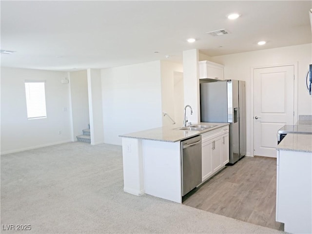 kitchen with sink, white cabinets, an island with sink, and appliances with stainless steel finishes