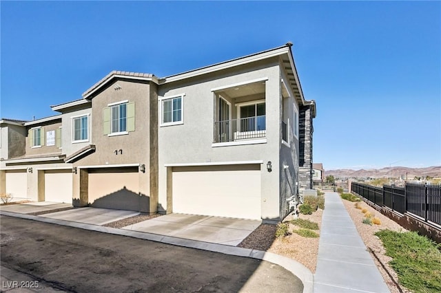 view of front of property featuring a mountain view, a balcony, and a garage