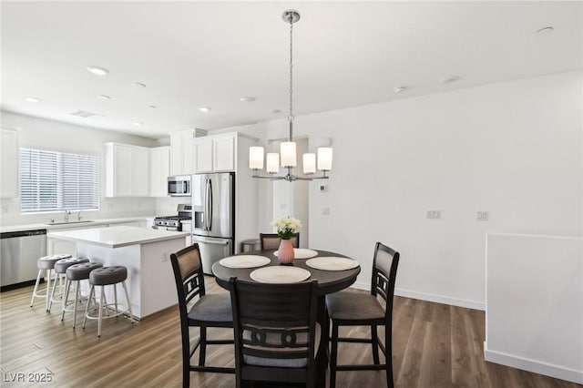 dining room featuring a chandelier, sink, and dark wood-type flooring