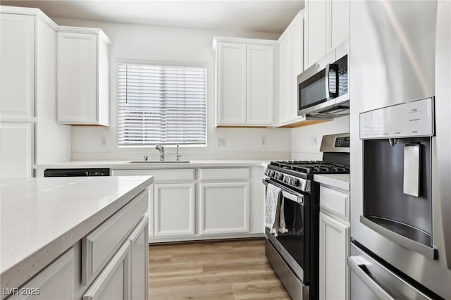 kitchen featuring light stone countertops, sink, white cabinets, and appliances with stainless steel finishes