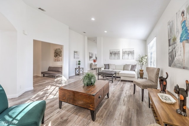 living room featuring light hardwood / wood-style flooring and lofted ceiling