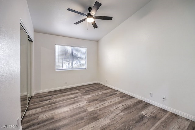 unfurnished bedroom featuring lofted ceiling, ceiling fan, dark hardwood / wood-style flooring, and a closet